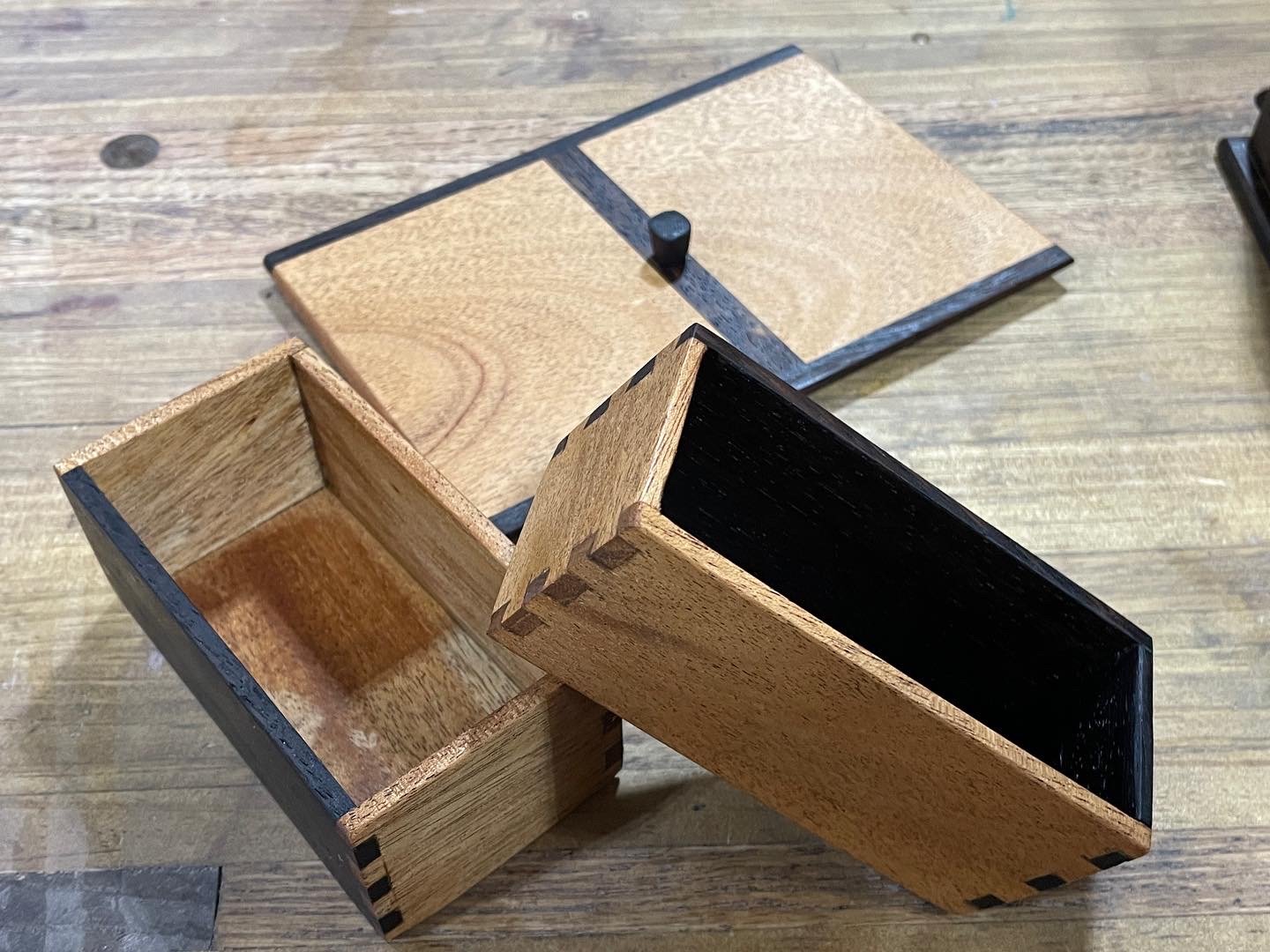 Lid and two interior boxes laid out: mahogany drawer with a wenge stripe and knob, an open mahogany tray, and a closed wenge pocket.