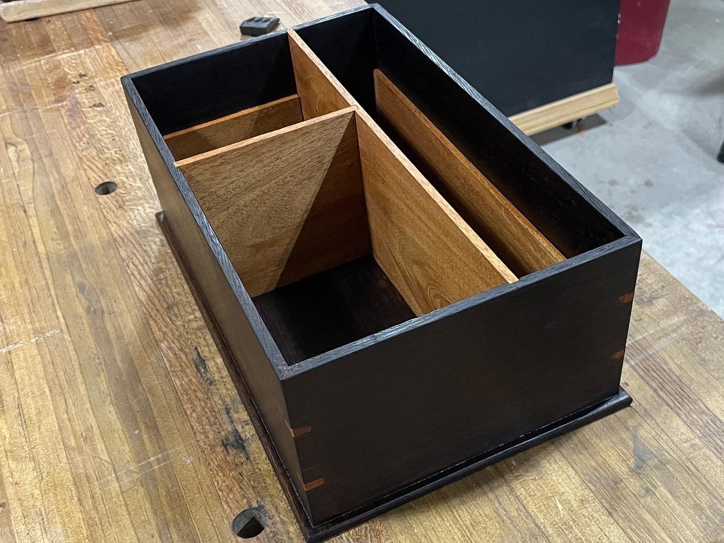 Three-quarter view of the empty wenge case with mahogany dividers and splined miter corners.