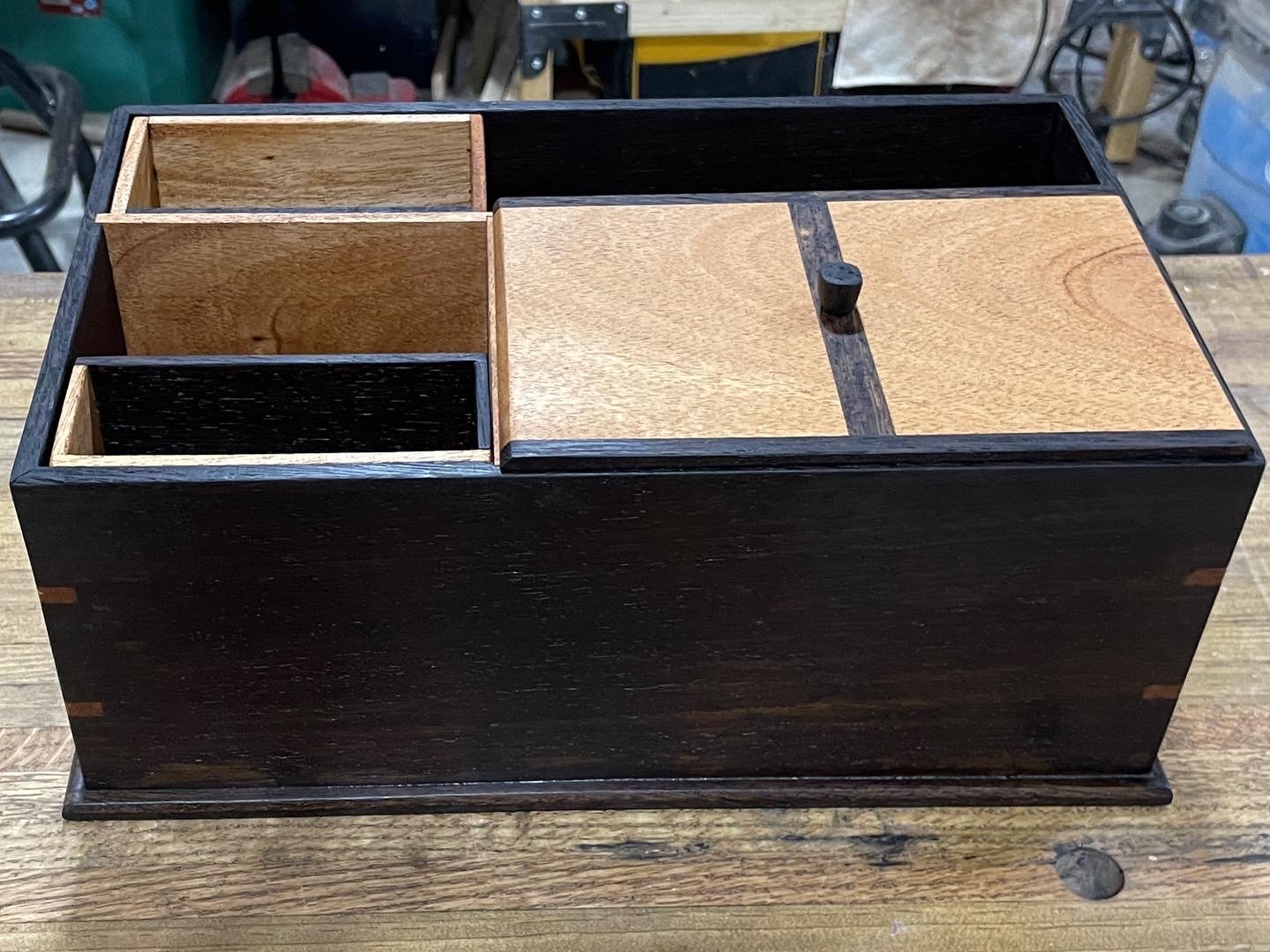 Front view of the finished box: dark wenge case, mahogany sliding lid with a small knob, and open pockets on the left.