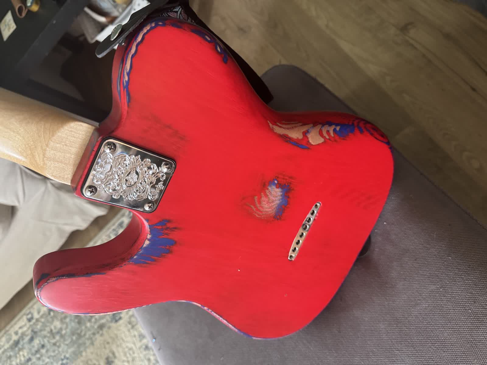 The back of The Izzy guitar showing the red and blue finish and engraved neck plate.