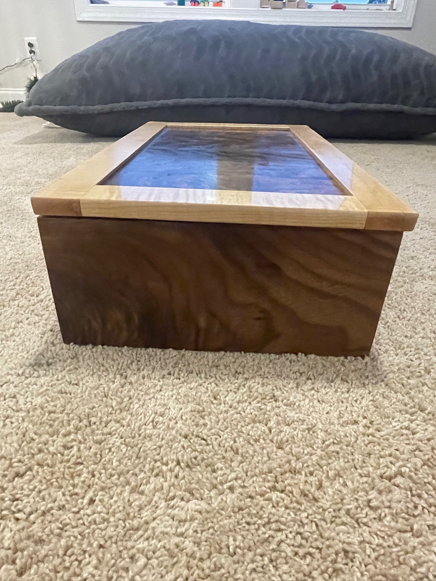 Front view of the closed box, showing the figured walnut lid panel and the solid case.